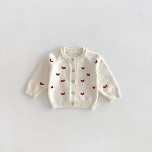 Vista dettagliata del cardigan in maglia da bambina bianco panna con ricami a cuore.