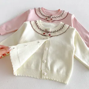 Detailed view of kids knit cardigan featuring delicate lace collar, embroidery and sweet cherry decor.