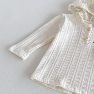 Detailed view of baby girl ribbed long sleeve top featuring delicate lace hood and wooden buttons.