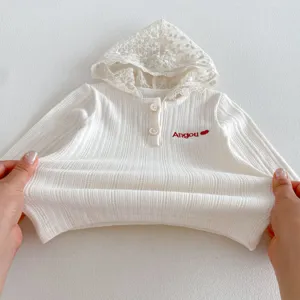 Detailed view of baby girl white ribbed hooded sweatshirt with delicate lace hood and buttons.