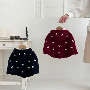 Vista detallada de capa infantil de forro polar con capucha y dulce estampado de corazones.
