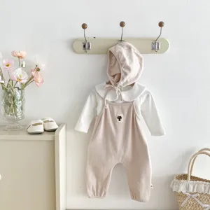 Detailed view of baby corduroy overalls set with cute cat patch, white collar shirt and bonnet.