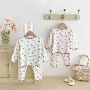 Detailed shot of cozy floral toddler long sleeve pajama sets hanging in a warm room setting.
