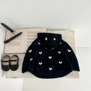 Vista detallada de la capa con capucha de felpa azul oscuro para bebé con corazones blancos.