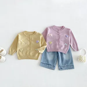 Infant knit cardigan set detail featuring cute embroidered hearts, bows and soft texture.