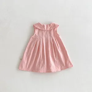 Detalle de vestido rosa sin mangas para bebé niña, cuello bonito y pliegues finos al frente.