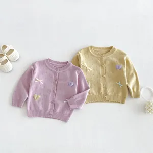 Toddler baby girl knit cardigan detail shot, cute heart embroidery and bow embellishment for autumn.