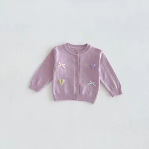 Baby girl knitted cardigan detail view, sweet purple sweater with cute heart and bow design.