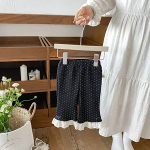 Toddler girls black polka dot flare pants with white lace ruffle hem and cute bow detail.