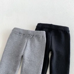 Detalle de pantalón de punto para bebé, gris y negro suave, cintura elástica cómoda.