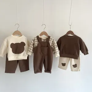 Vista detallada de sudadera y peto de bebé oso, bonito estampado de parche en tonos marrones neutros.