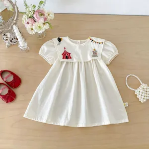 Dettaglio del vestito bianco da bambina con ricamo circo carino e maniche a palloncino eleganti.