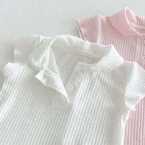 Close-up detail of infant ribbed polo collar short sleeve t-shirt in white and pink soft cotton.