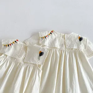Dettaglio del vestito estivo senza maniche da bambina con colletto ricamato in cotone.