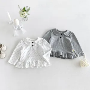 Detailed showcase of infant polka dot long-sleeve top featuring cute doll collar and ruffled hem.
