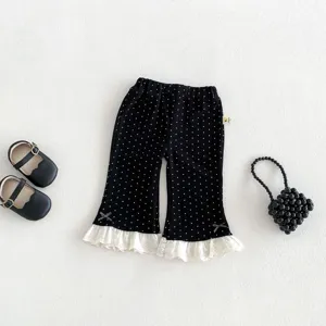 Detailed view of baby girl polka dot flared pants with white lace ruffles and cute bows.