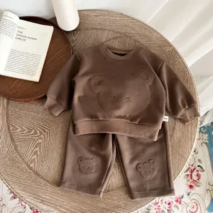 Vista detallada del conjunto de sudadera y pantalón para bebé con bordado de oso.