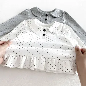Detailed view of cute infant toddler polka dot long sleeve blouse with peter pan collar.