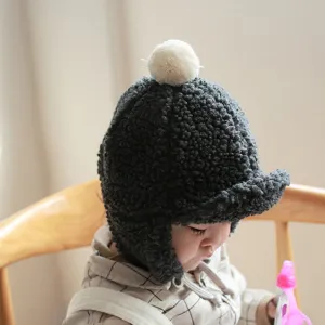 Detailed shot of baby winter warm fleece earflap hat with cute pom pom, soft texture, cozy look.