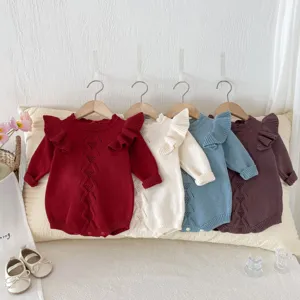 Close-up view of baby knit rompers showing delicate hollow-out diamond pattern and ruffles.