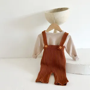 Gebreide baby trui met lange mouwen en bruine bretelbroek set, stijlvolle comfortabele outfit.
