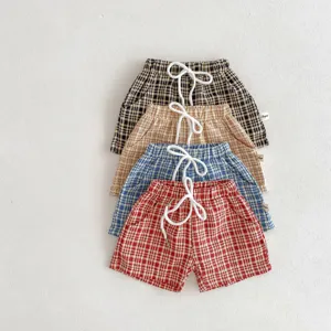 Shorts décontractés à carreaux pour enfants avec taille élastique et jolis cordons blancs.