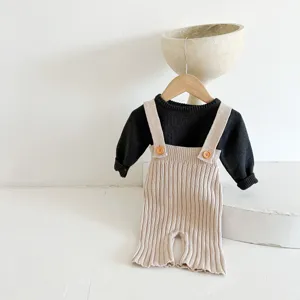 Baby gebreide trui en bretelbroek set detail, comfortabele katoenen kleding voor herfst.