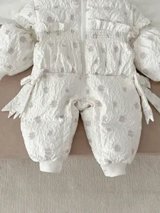 Infant winter down jumpsuit detail view, white floral print, cute baby girl warm outerwear.