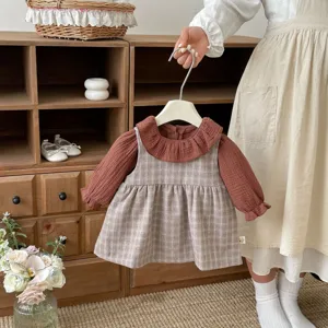Vista dettagliata di un grazioso completo primaverile da bambina con colletto e vestito a quadri.