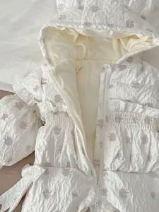 Detail shot of infant winter down jumpsuit, white with pink floral, warm hooded design.