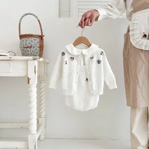 Infant baby girl white knit sweater and romper detail, cute floral embroidery, delicate design.