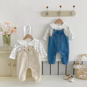Baby clothing detail view showing cute ruffle collar top and denim overalls set for infants.