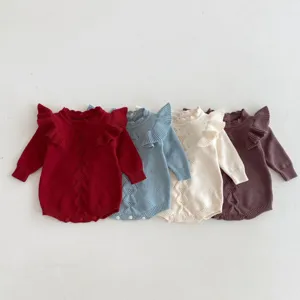 Detailed view of cute baby knitted romper featuring ruffle sleeves and hollow pattern.