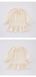 Détail robe manches longues bébé fille, col nœud beige et ourlet à volants délicat.