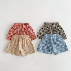 Détail de short à carreaux d'été pour bébé, tissu respirant avec taille élastique.