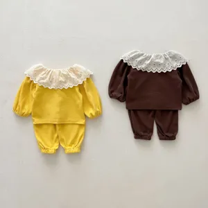 Infant waffle weave two-piece set detail, featuring a cute white lace collar and long sleeves.