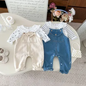 Detailed closeup view of cute infant baby denim overalls set with sweet ruffle collar shirt.