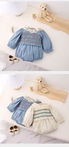 Detailed view of baby girl long sleeve romper with frilly lace collar and smocked bubble sleeves.