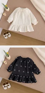 Détails en gros plan de la robe à manches longues brodée de nœuds pour petite fille avec volant.