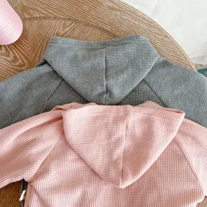Infant waffle knit hooded jacket detail view, soft cotton baby autumn clothing set.