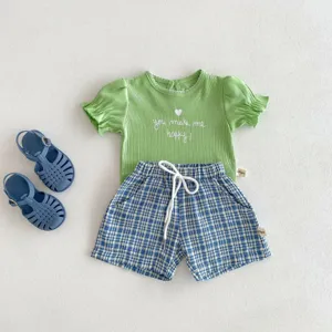 Vue détaillée de l'ensemble t-shirt et short à carreaux pour bébé avec imprimé.