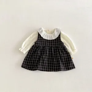 Completo grazioso per bambina con abito scamiciato a quadri e camicetta bianca.