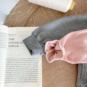 Detailed shot of baby waffle knit hoodie jacket and pants set in grey and pink colors.
