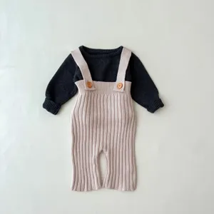 Gedetailleerd overzicht van baby trui en tuinbroek van zacht breisel met houten knopen.