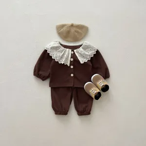 Detailed flat lay of toddler girl brown waffle knit clothing set with lace collar and matching hat.