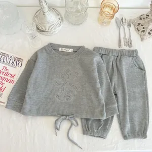 Adorable baby waffle knit clothing set featuring a cozy crewneck sweatshirt and matching pants.