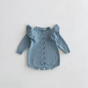 Close-up detail of the cute light blue knitted baby romper showcasing ruffle shoulders and knit.