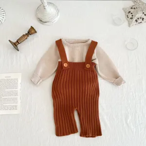 Gedetailleerde gebreide baby set met trui en broek met bretels in beige en bruin.