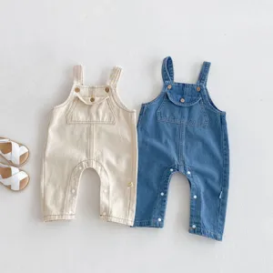 Cute baby denim overalls detail shot, featuring snap buttons and front pocket for infants.