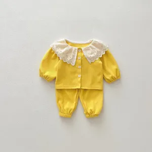 Details of cute baby waffle knit top with large lace collar and matching trousers.